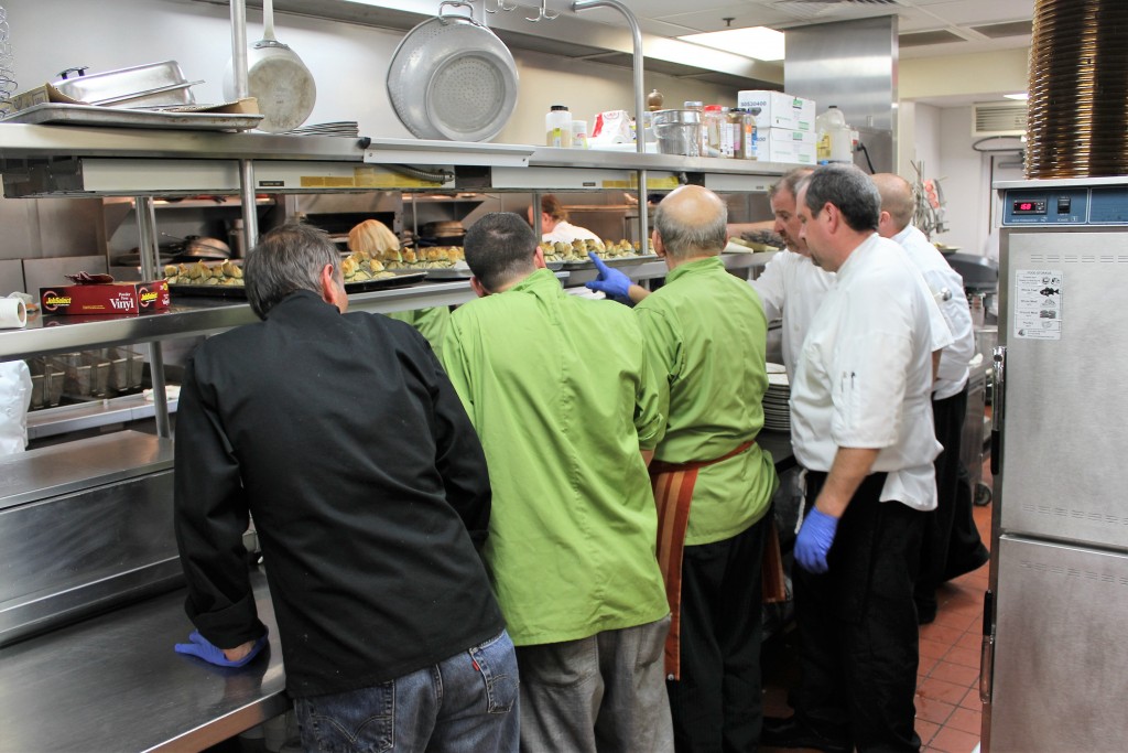 A quick meeting with the kitchen staff as they prepare to serve the 4th course