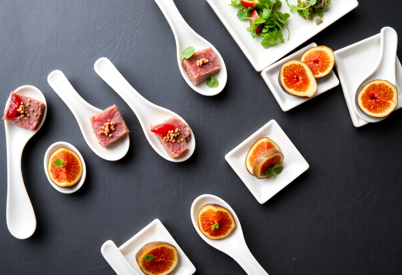 Gourmet hors d oeuvres on white tasting spoons on slate