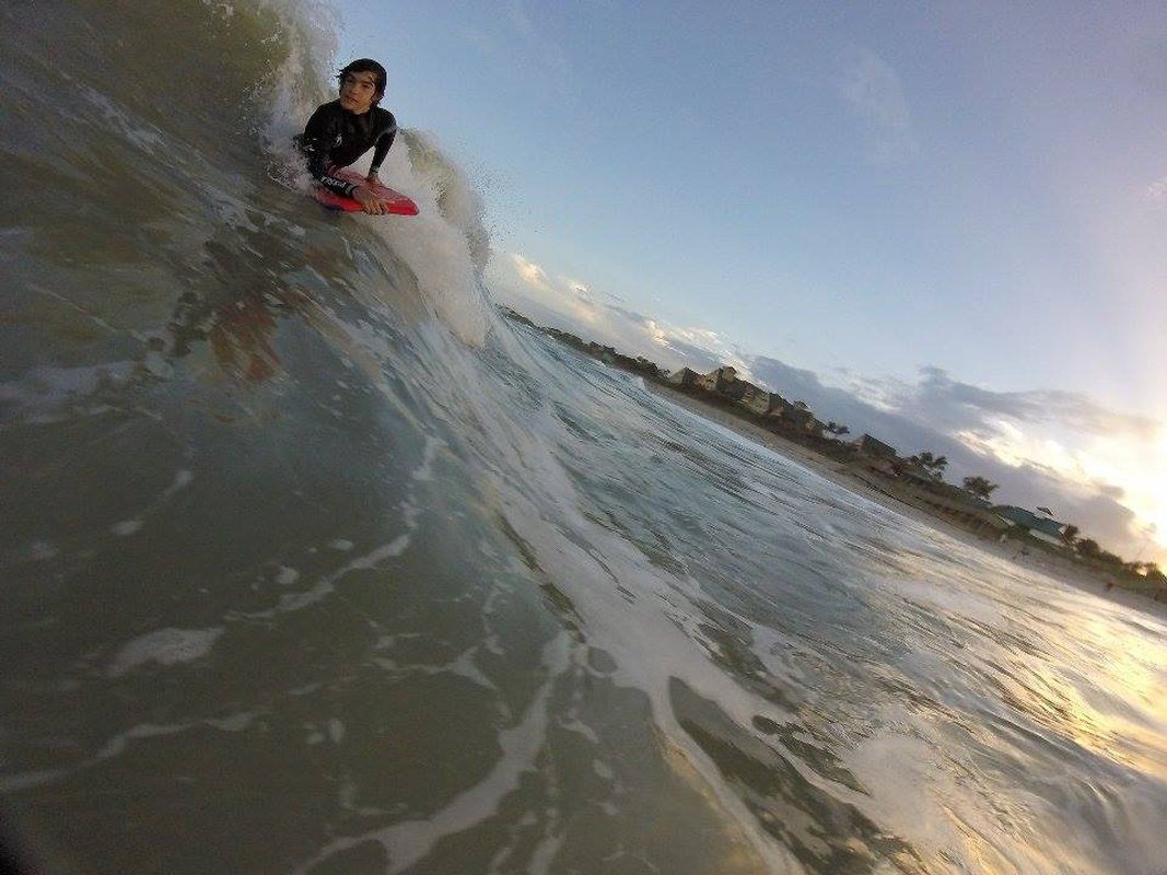 Youngling Rideing A Wave Beautiful Sunset